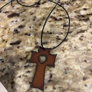 Metal Cross Pendant with shaped heart in the middle.  Comes with chain cord.